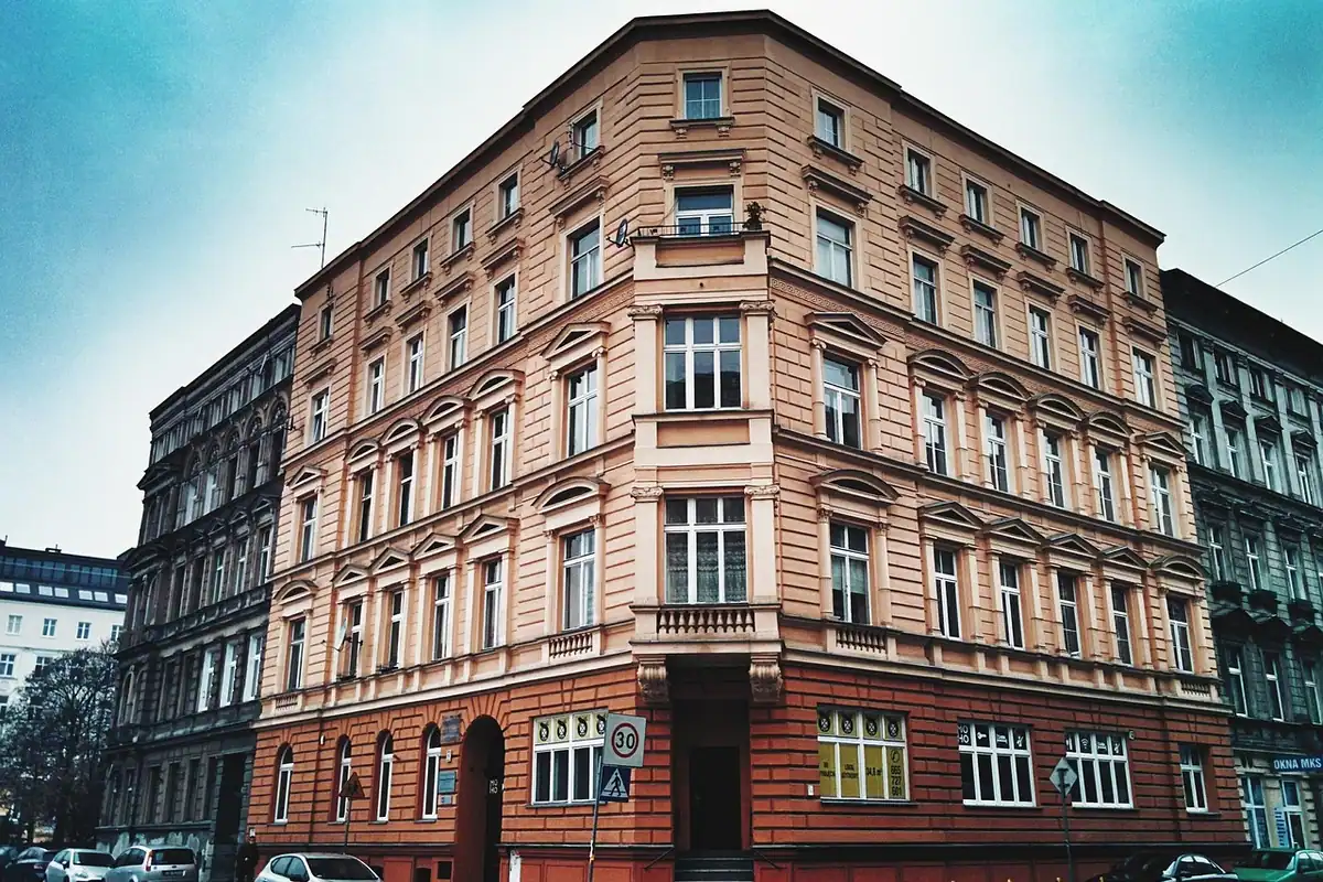 Stradă dintr-un oraș cu blocuri de apartamente cu ferestre, văzută la nivelul străzii