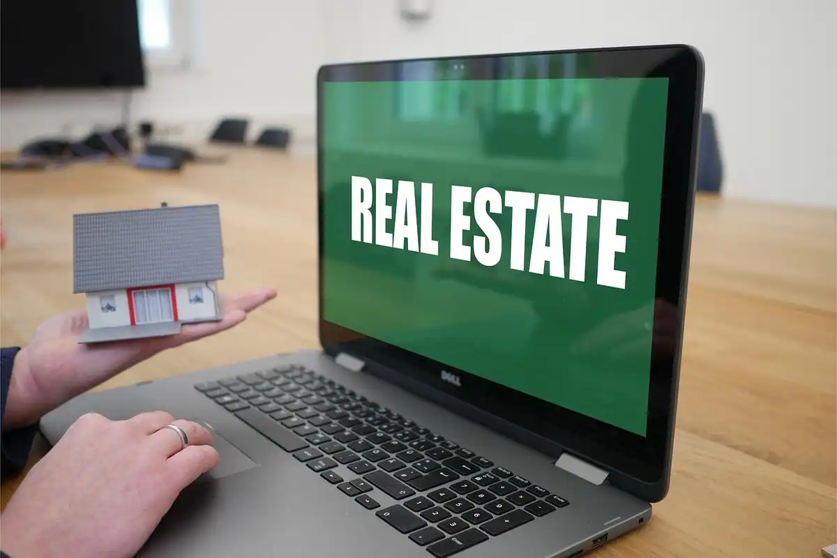 Persoană care caută apartamente de închiriat pe laptop, cu anunțuri imobiliare afișate pe ecran