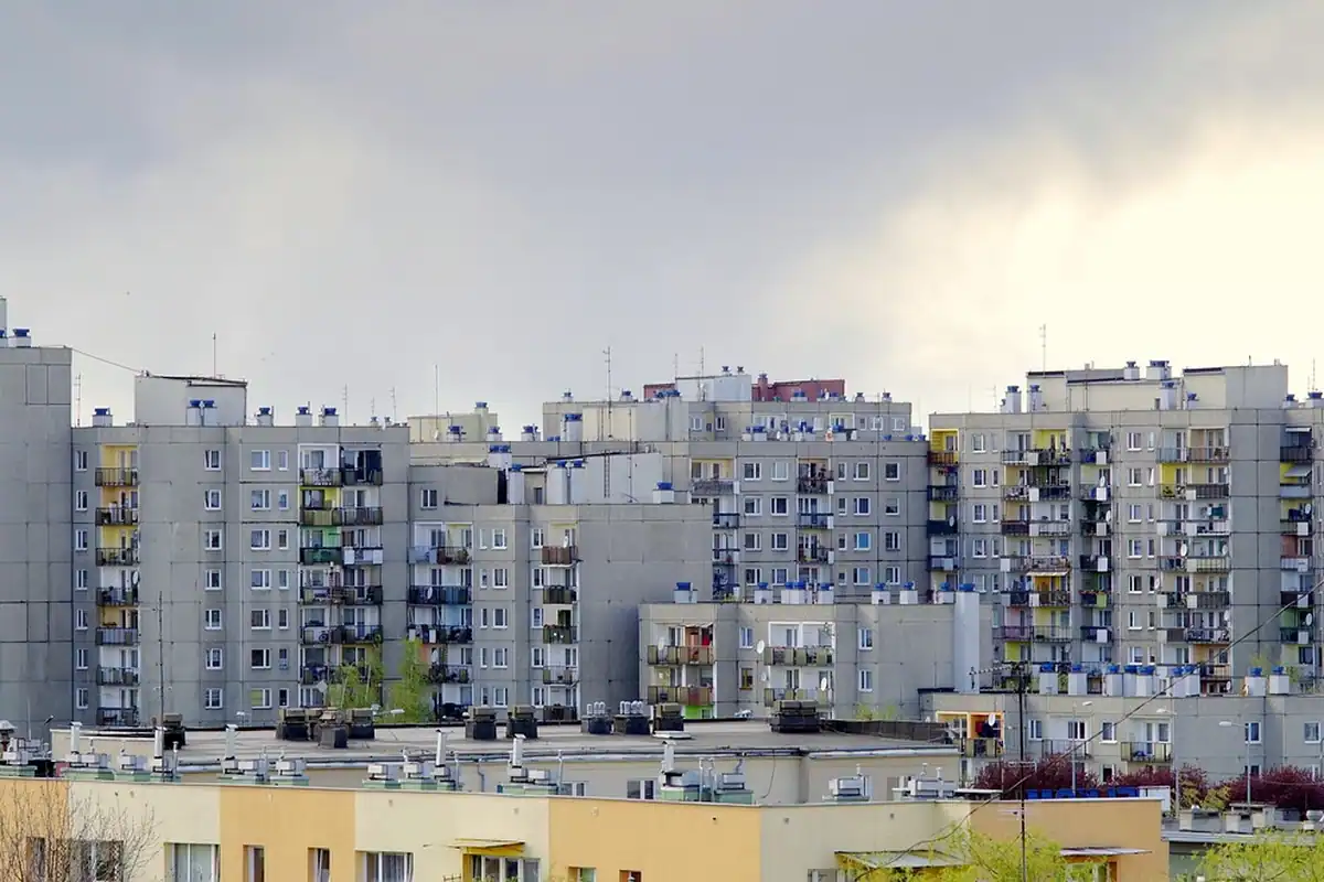 Blocuri gri de locuințe pe fundal de cer înnorat, într-un cartier dens