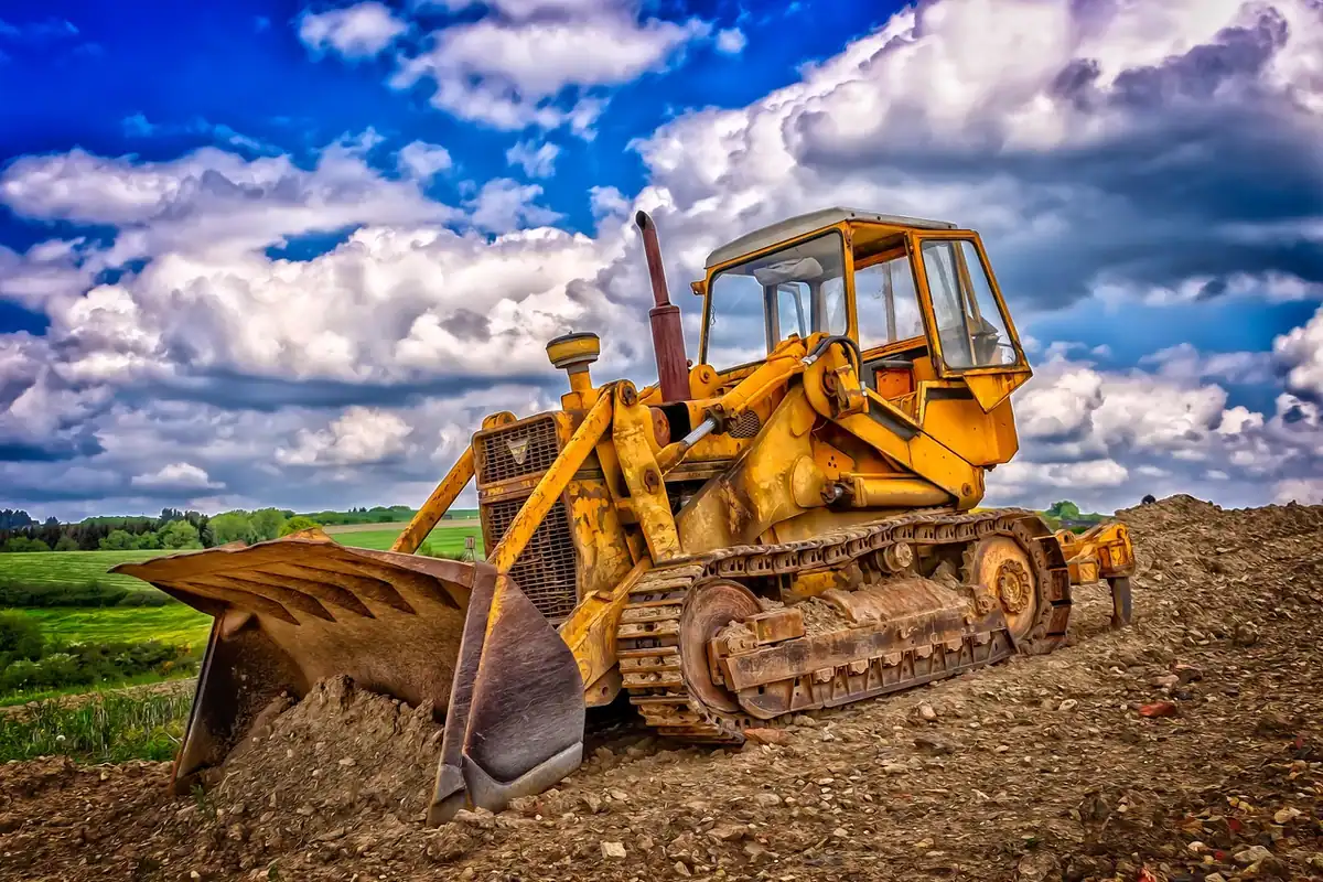 Excavator pe șenile care sapă pe un șantier de construcții, în pregătirea unui teren de casă